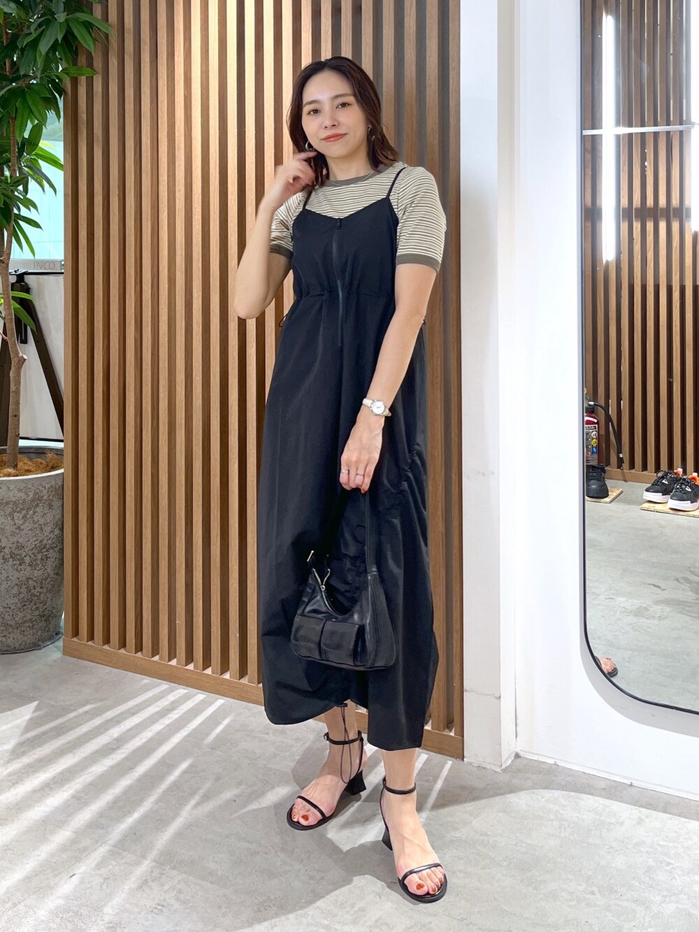 グリーン系のTシャツ/カットソー、ブラック系のショルダーバッグ、ブラック系のサンダルを着用したレディースの春コーディネートの3枚目の写真