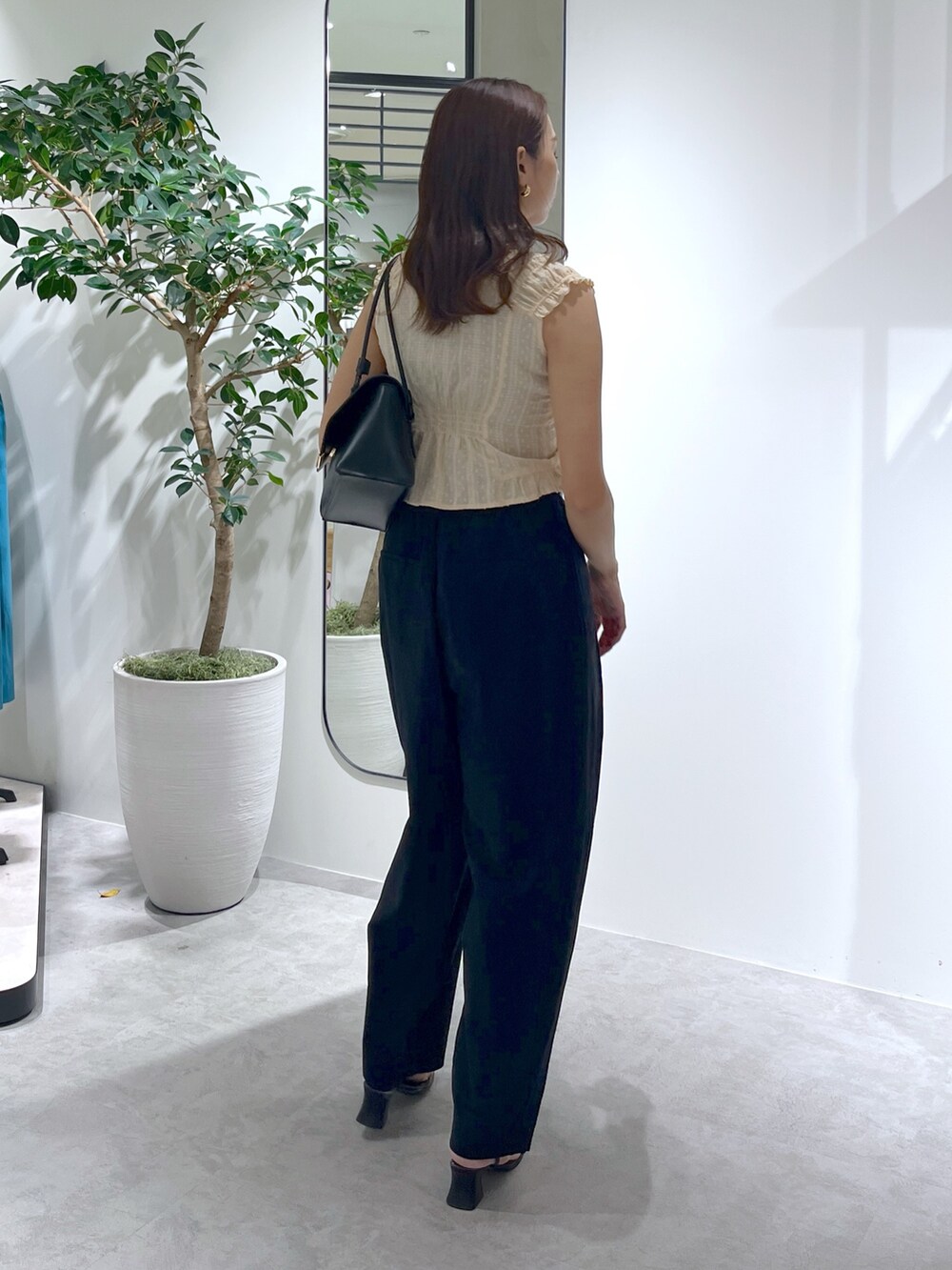 ブラック系のショルダーバッグ、ブラック系のパンツ、イエロー系のシャツ/ブラウスを着用したレディースの夏コーディネートの7枚目の写真