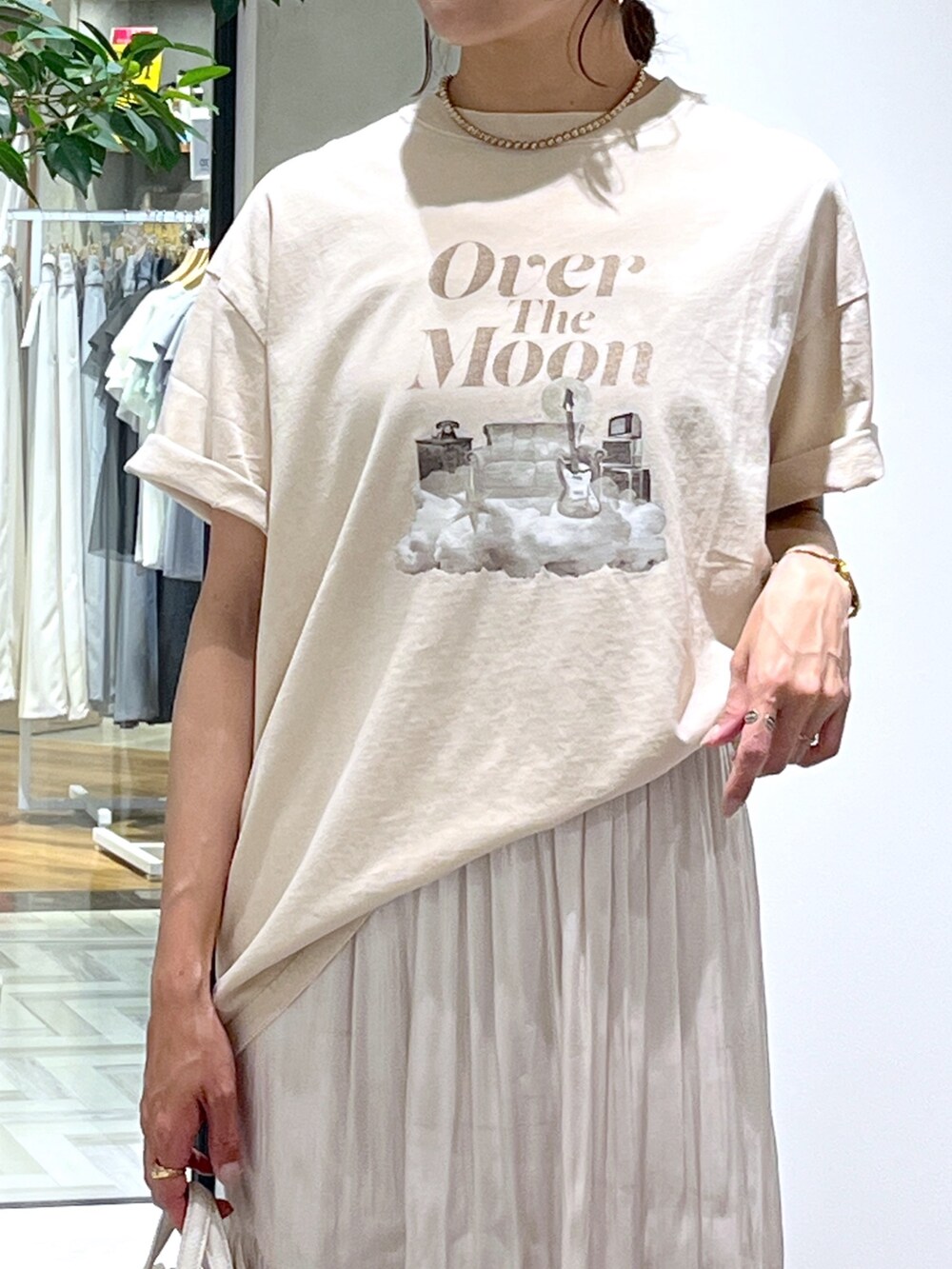 ベージュ系のTシャツ/カットソー、ホワイト系のショルダーバッグ、ホワイト系のスカートを着用したレディースの春コーディネートの7枚目の写真