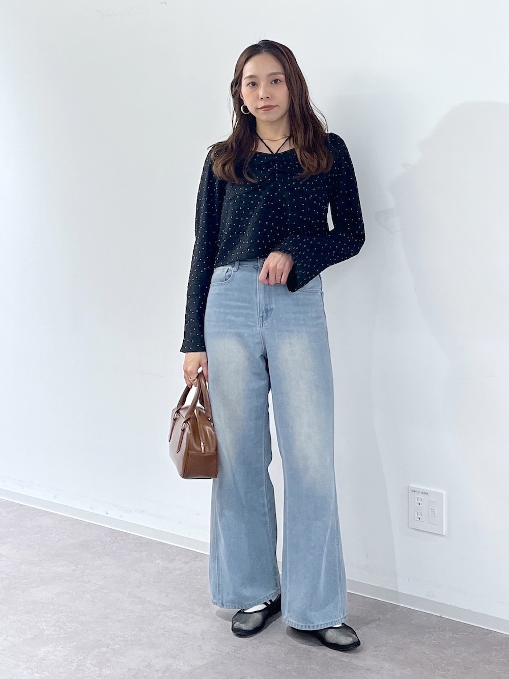 ブラック系のシャツ/ブラウス、ブラウン系のハンドバッグ、ブラック系のパンプスを着用したレディースの冬コーディネートの3枚目の写真