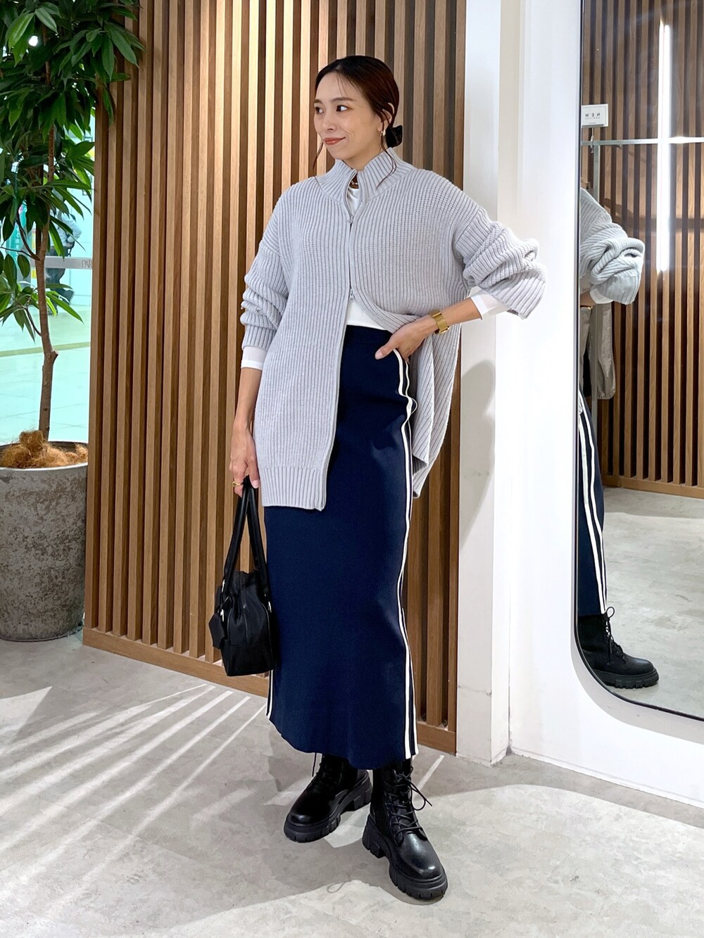 ホワイト系のTシャツ/カットソー、グレー系のワンピース、ブルー系のスカートを着用したレディースの秋コーディネートの3枚目の写真