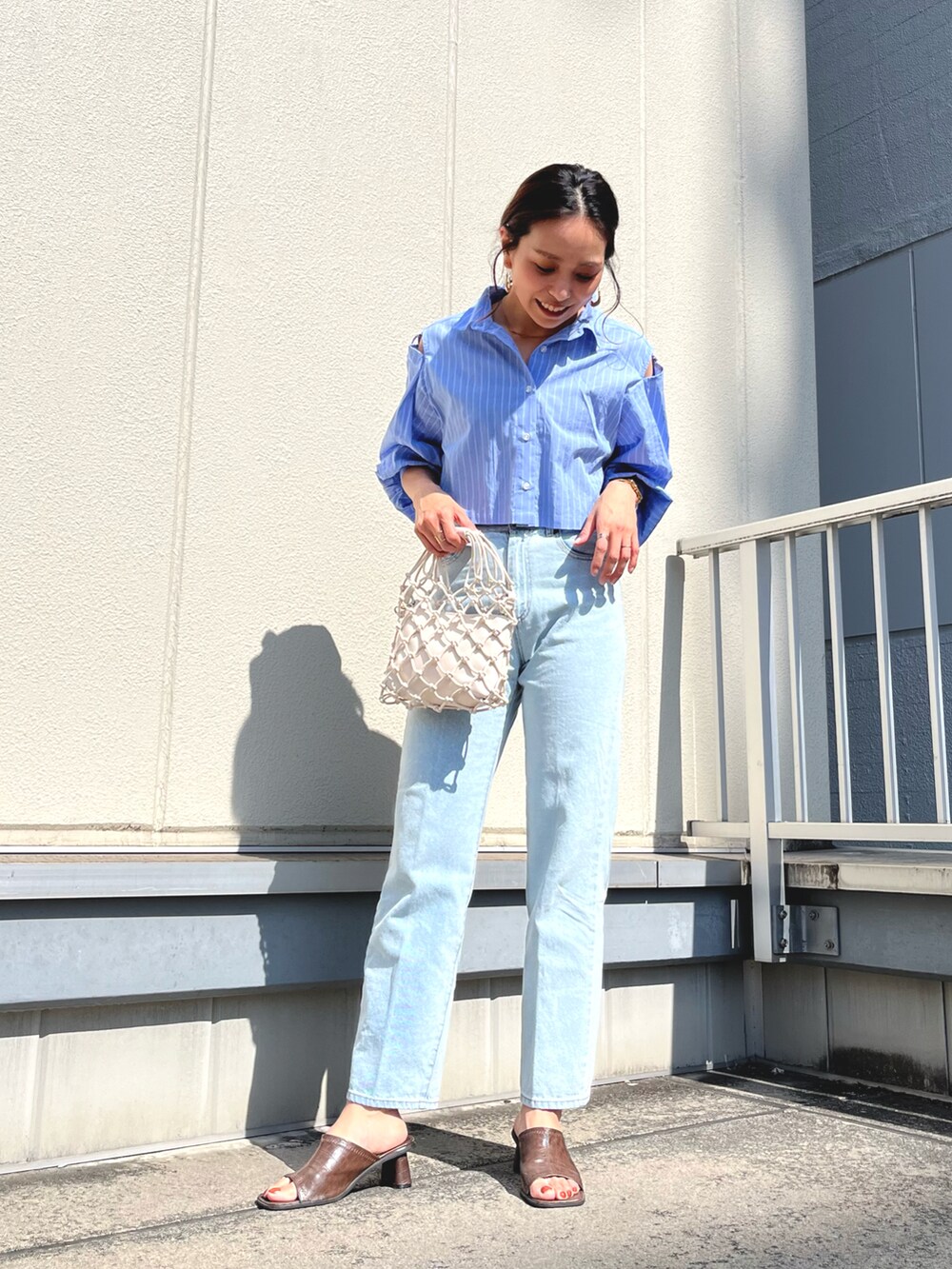 ブルー系のシャツ/ブラウス、ブルー系のデニムパンツを着用したレディースの春コーディネートの3枚目の写真