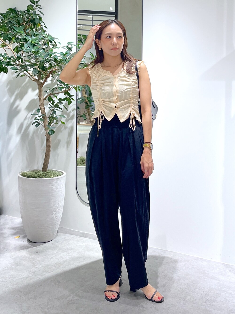 ブラック系のショルダーバッグ、ブラック系のパンツ、イエロー系のシャツ/ブラウスを着用したレディースの夏コーディネートの9枚目の写真