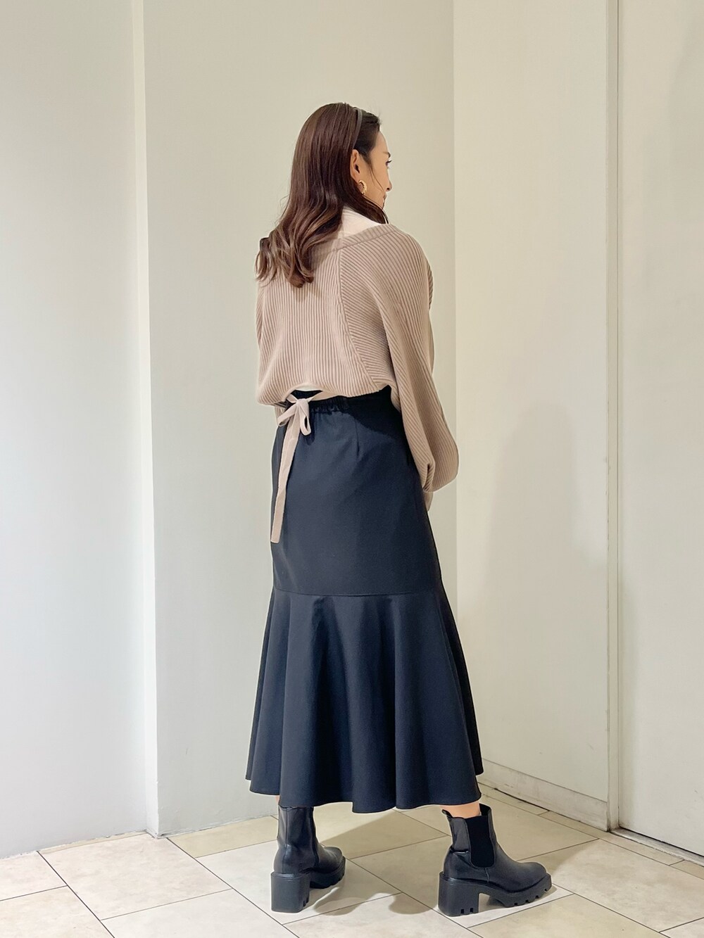 ブラウン系のカーディガン/ボレロ、ブラック系のスカート、ホワイト系のTシャツ/カットソーを着用したレディースの秋コーディネートの3枚目の写真