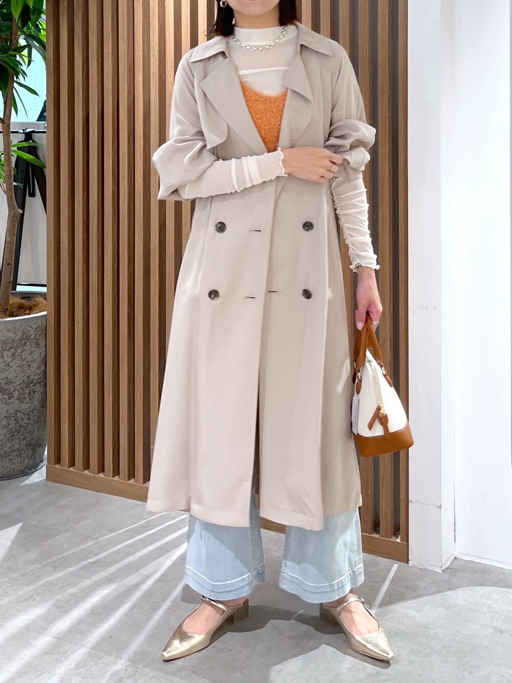 ブラウン系のショルダーバッグ、ホワイト系のTシャツ/カットソー、オレンジ系のベストを着用したレディースの春コーディネートの7枚目の写真