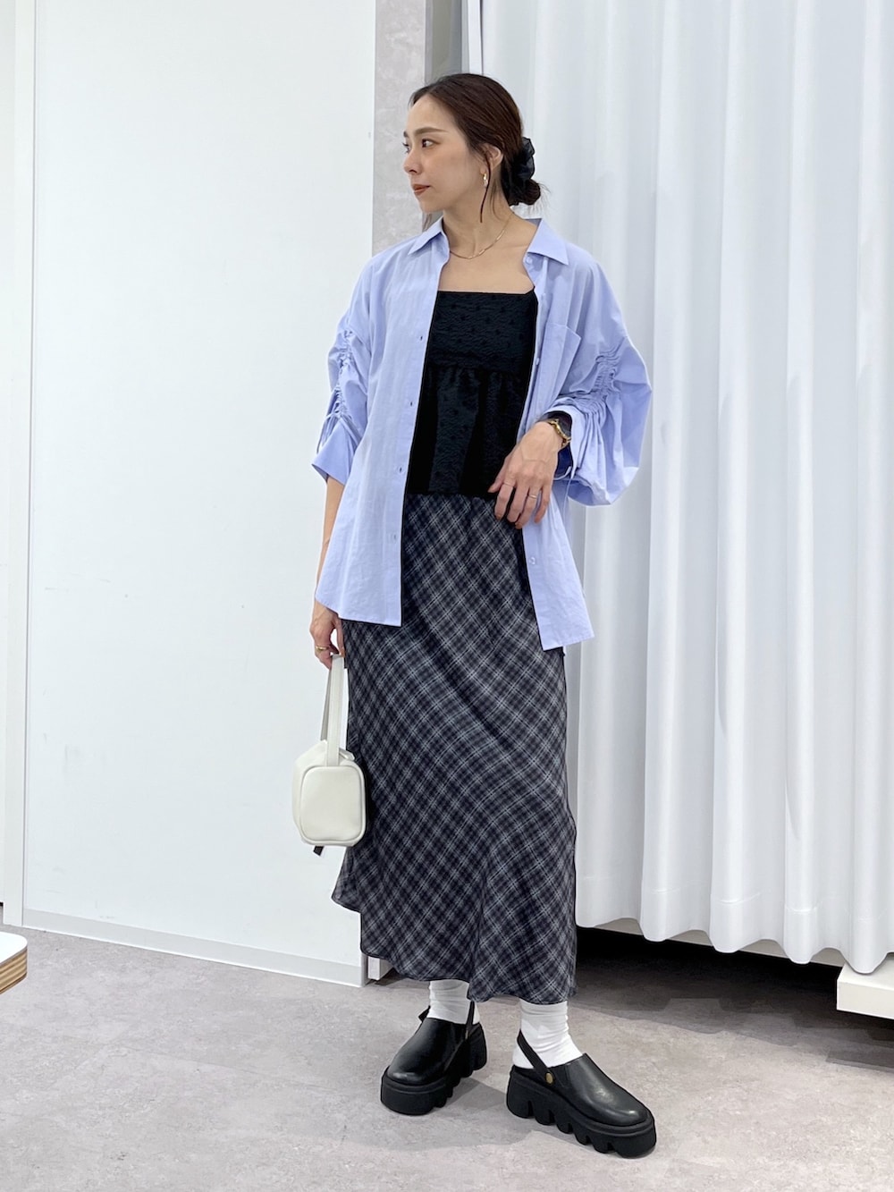 ホワイト系のハンドバッグ、ブルー系のシャツ/ブラウス、ブラック系のシャツ/ブラウスを着用したレディースの春コーディネートの2枚目の写真