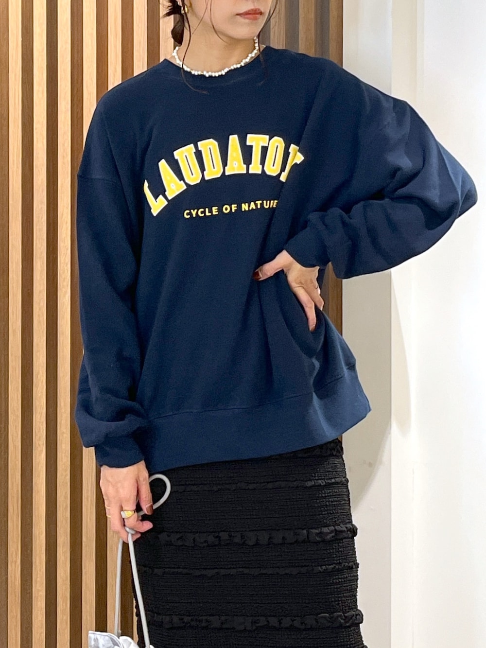 ブルー系のスウェット、ブラック系のスカート、グレー系のハンドバッグを着用したレディースの秋コーディネートの6枚目の写真