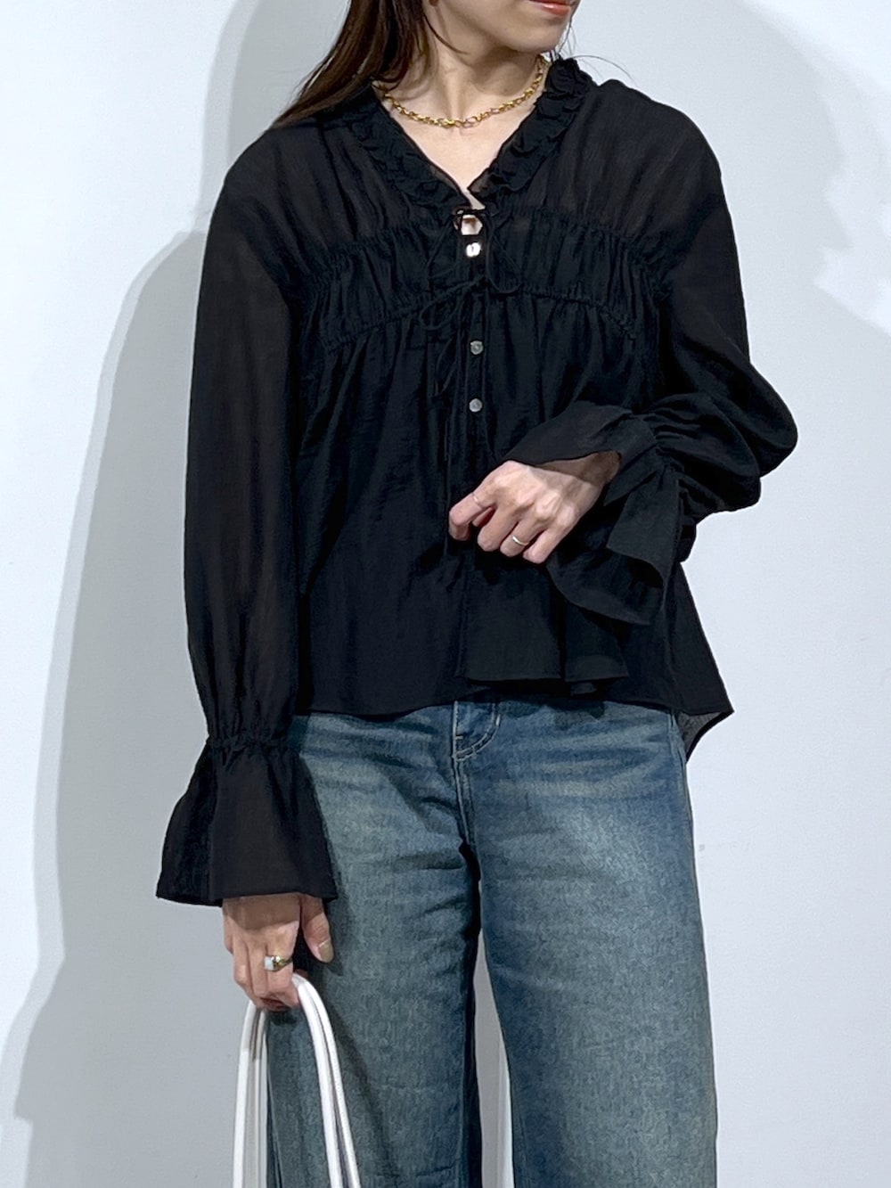 ブラック系のシャツ/ブラウス、ブルー系のデニムパンツを着用したレディースの春コーディネートの6枚目の写真