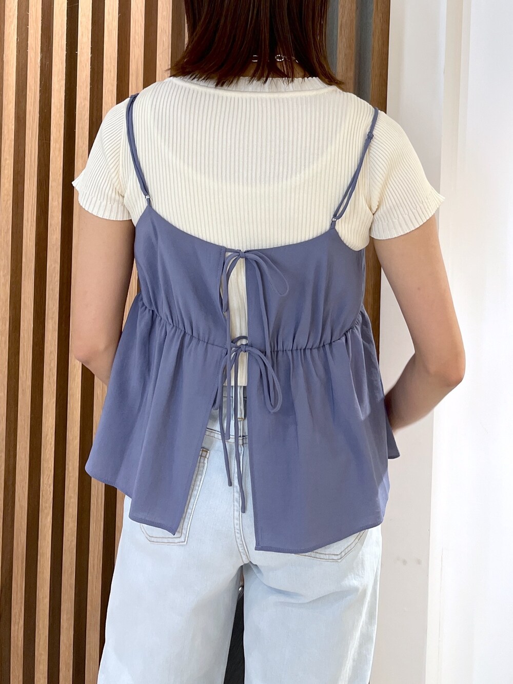 ホワイト系のニット/セーター、ブルー系のシャツ/ブラウス、ブルー系のデニムパンツを着用したレディースの夏コーディネートの6枚目の写真