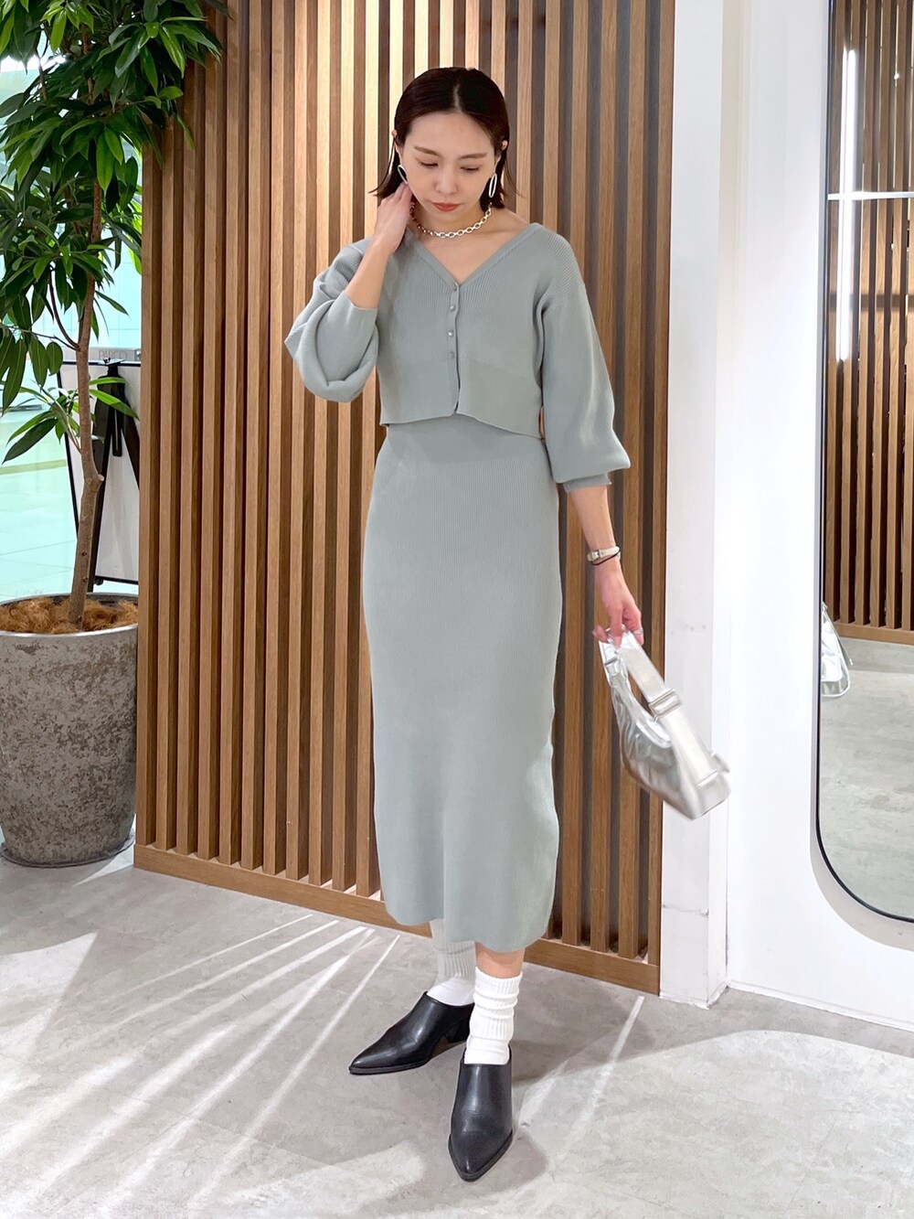 グリーン系のカーディガン/ボレロ、シルバー系のショルダーバッグ、グリーン系のワンピースを着用したレディースの冬コーディネートの3枚目の写真