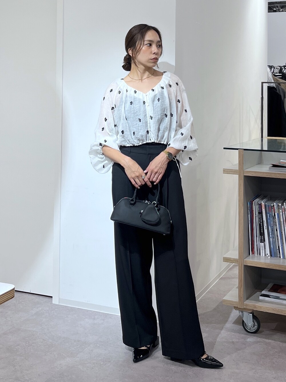 ブラック系のボストンバッグ、ブラック系のスラックス、ブラック系のパンプスを着用したレディースの夏コーディネートの9枚目の写真