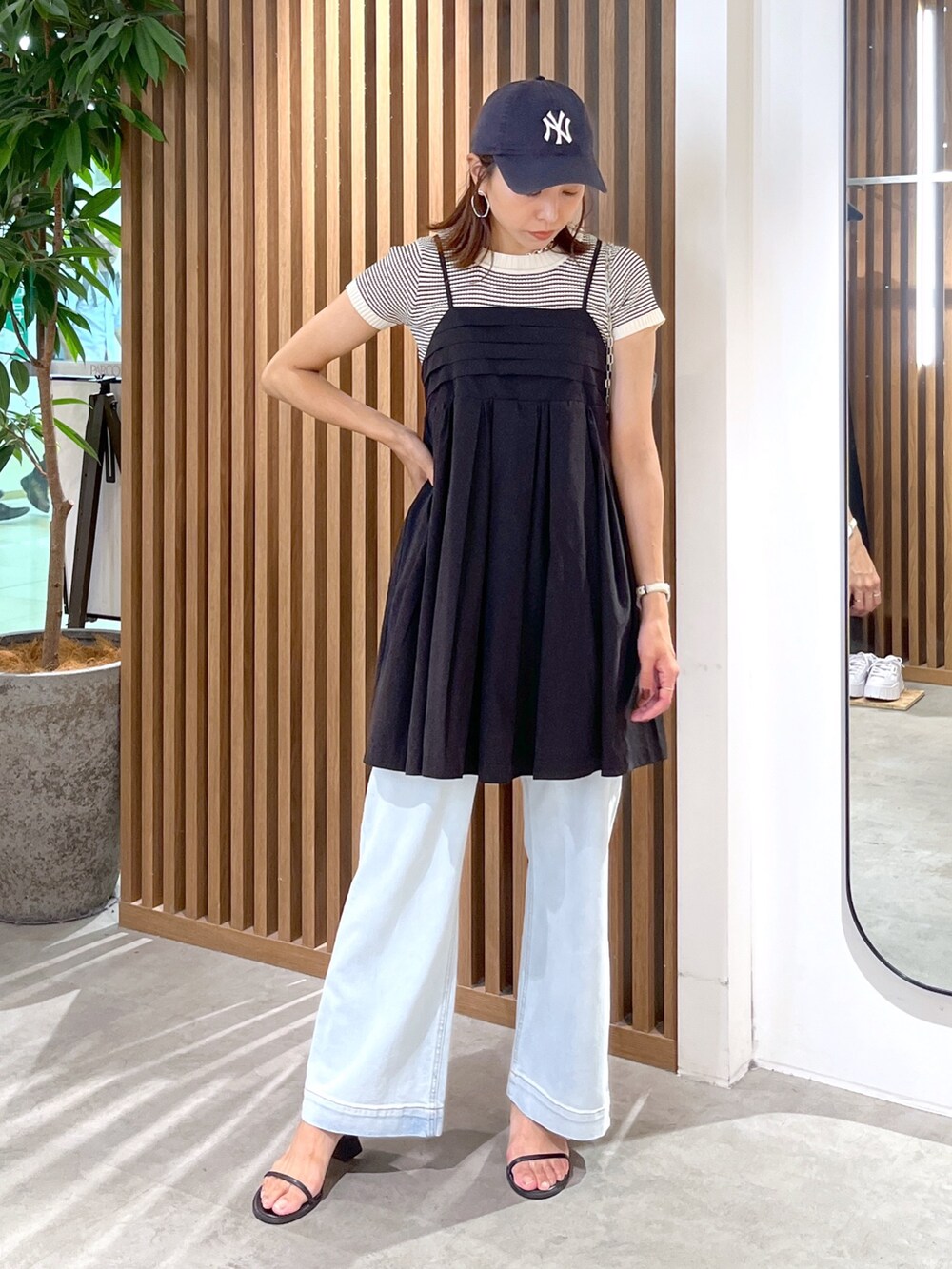 ブラック系のサンダル、ブルー系のデニムパンツ、ブラック系のワンピースを着用したレディースの夏コーディネートの3枚目の写真