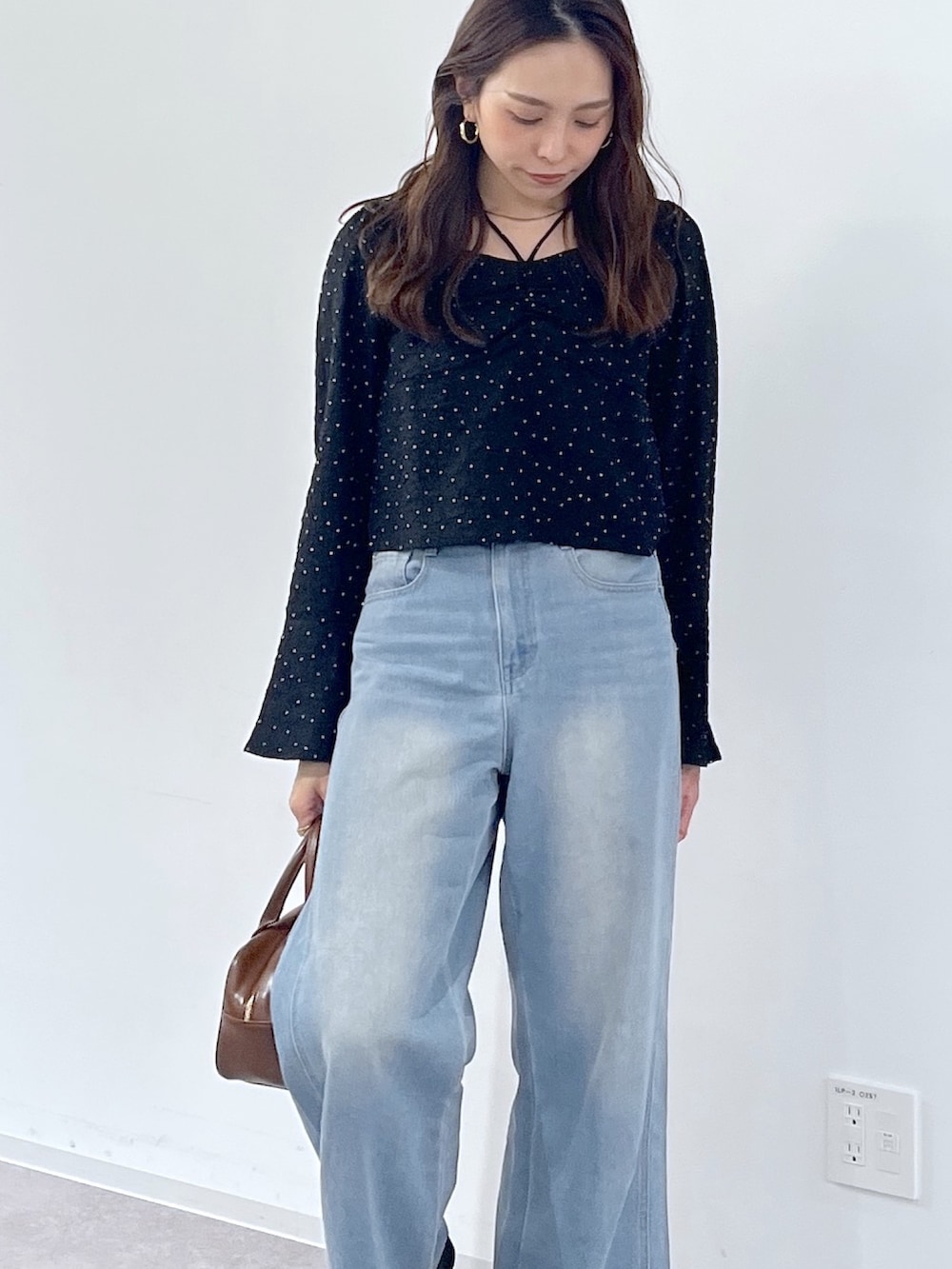 ブラック系のシャツ/ブラウス、ブラウン系のハンドバッグ、ブラック系のパンプスを着用したレディースの冬コーディネートの6枚目の写真