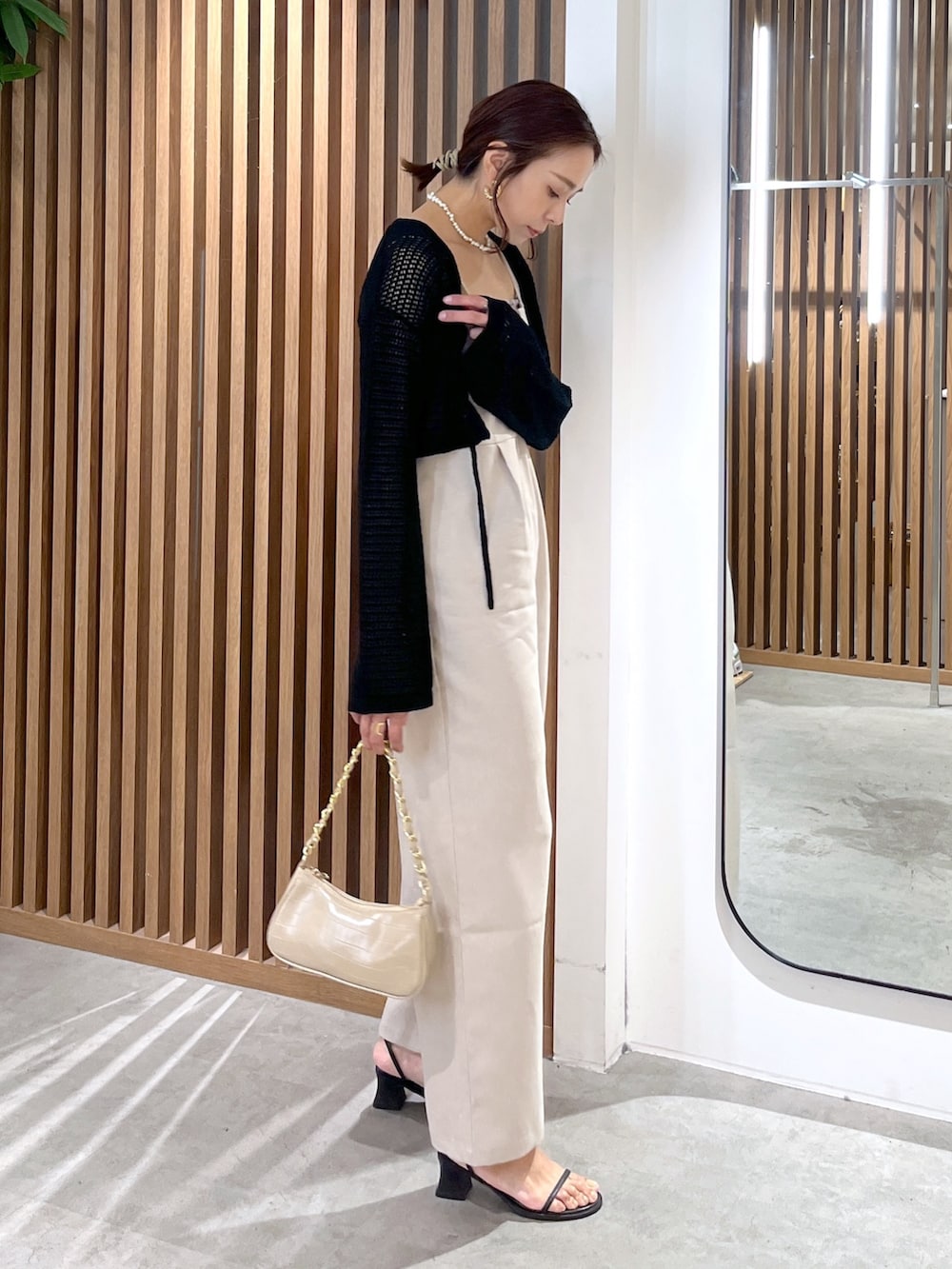 ブラック系のカーディガン/ボレロ、グレー系のキャミソール、ベージュ系のトートバッグを着用したレディースの夏コーディネートの3枚目の写真