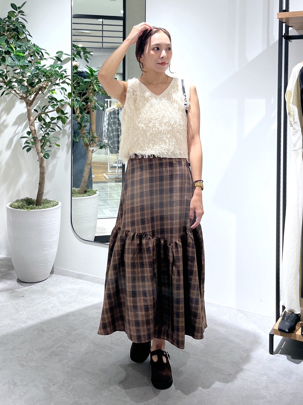 ブラウン系のシューズ、ブラック系のショルダーバッグ、ホワイト系のニット/セーターを着用したレディースの夏コーディネートの5枚目の写真