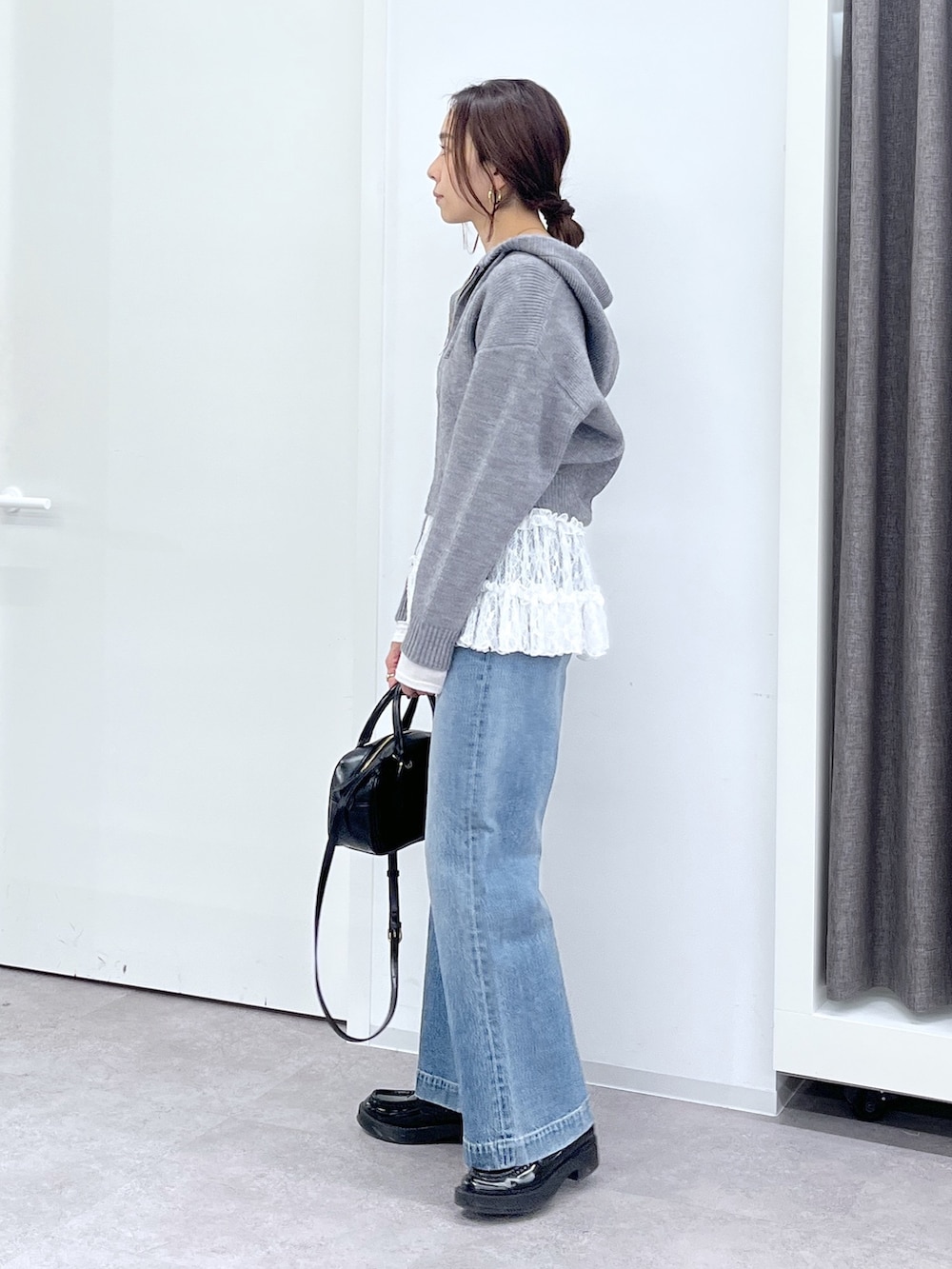 ブラック系のショルダーバッグ、ブルー系のデニムパンツ、ホワイト系のTシャツ/カットソーを着用したレディースの冬コーディネートの6枚目の写真