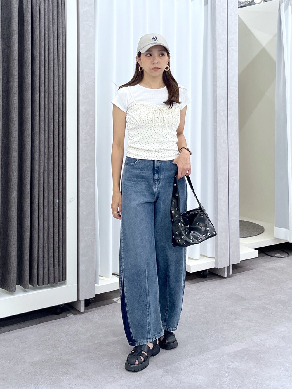 ホワイト系のTシャツ/カットソー、ブルー系のデニムパンツ、ブラック系のショルダーバッグを着用したレディースの夏コーディネートの3枚目の写真
