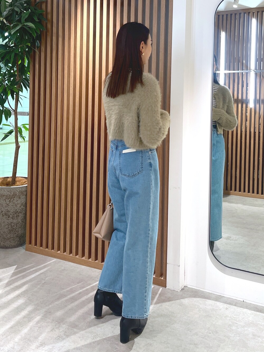 ベージュ系のカーディガン/ボレロ、ブルー系のデニムパンツ、ホワイト系のニット/セーターを着用したレディースの冬コーディネートの6枚目の写真