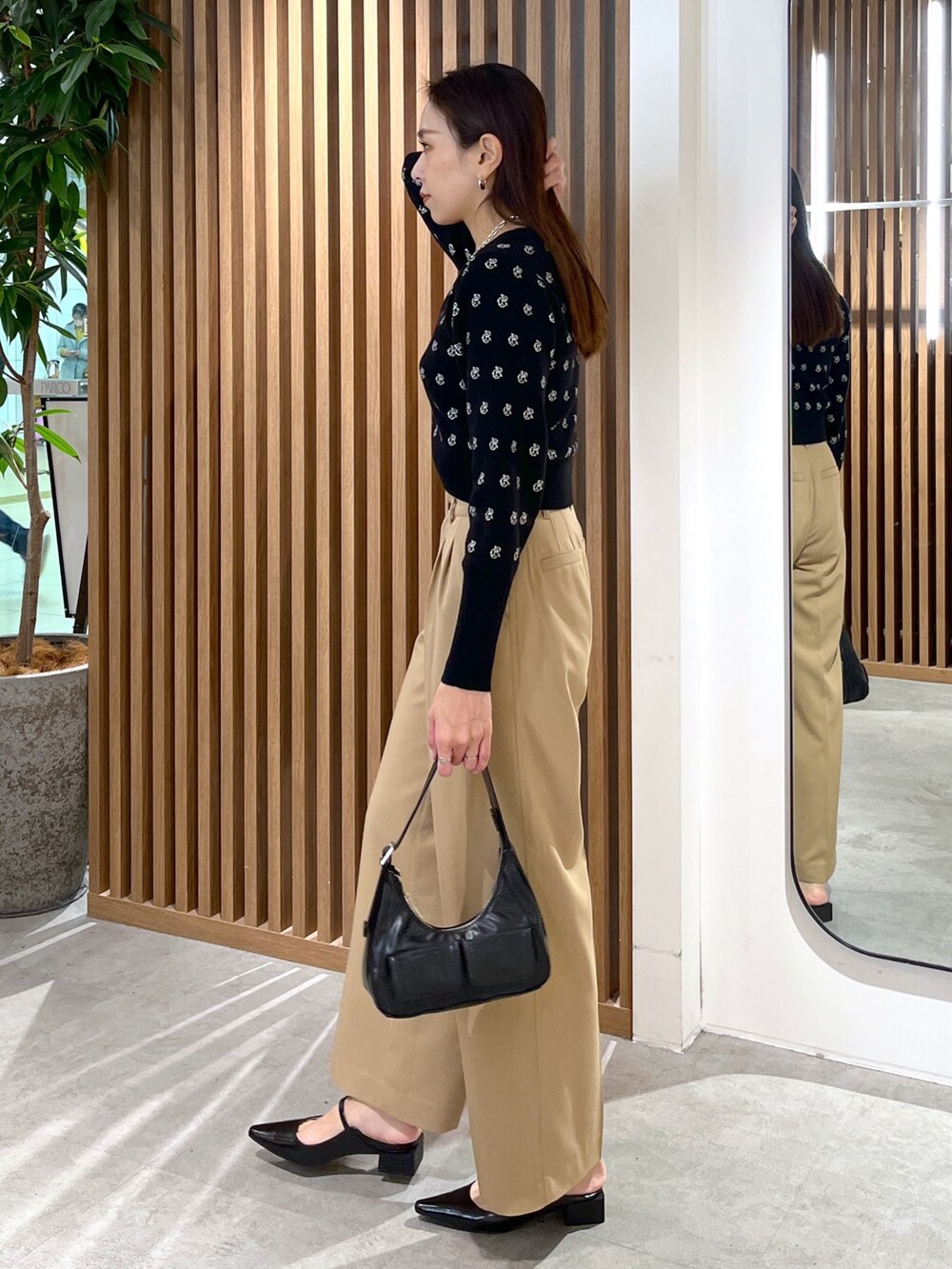 ブラック系のパンプス、ブラック系のショルダーバッグ、ブラック系のニット/セーターを着用したレディースの冬コーディネートの5枚目の写真