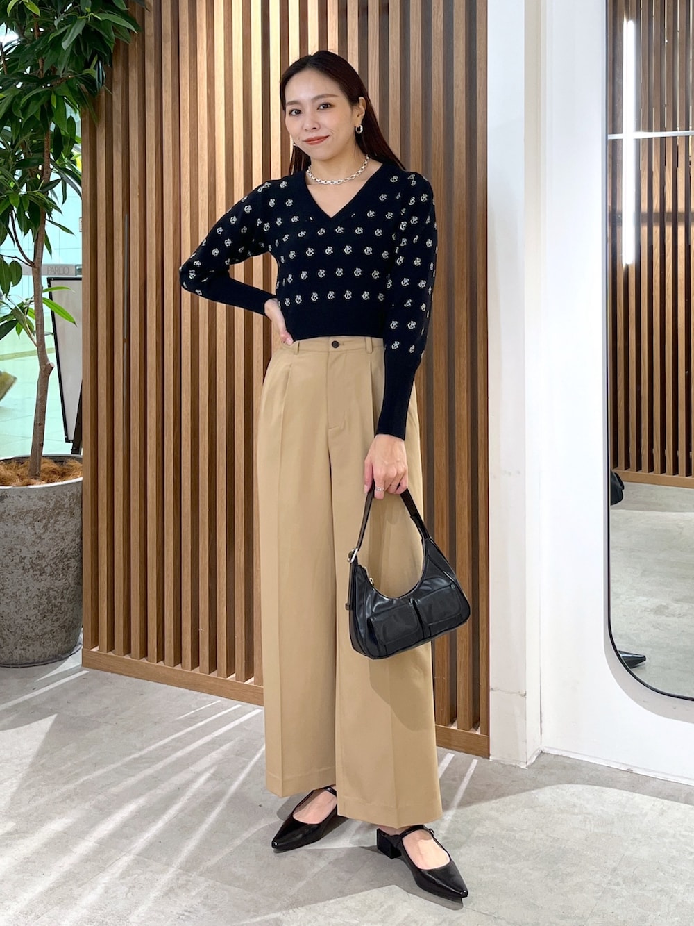 ブラック系のパンプス、ブラック系のショルダーバッグ、ブラック系のニット/セーターを着用したレディースの冬コーディネートの3枚目の写真