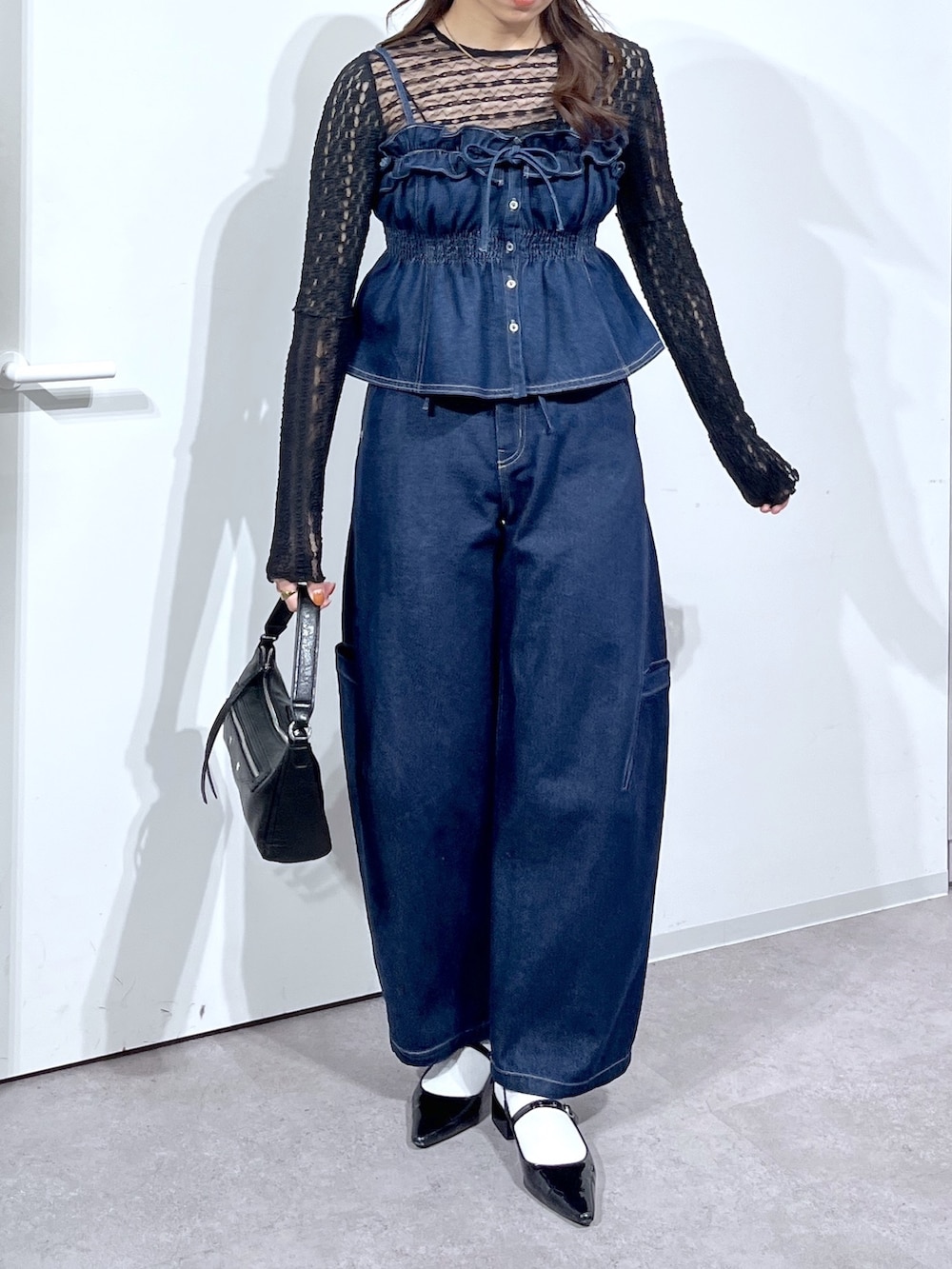 ブラック系のTシャツ/カットソー、ブルー系のシャツ/ブラウス、ブラック系のバッグを着用したレディースの春コーディネートの6枚目の写真