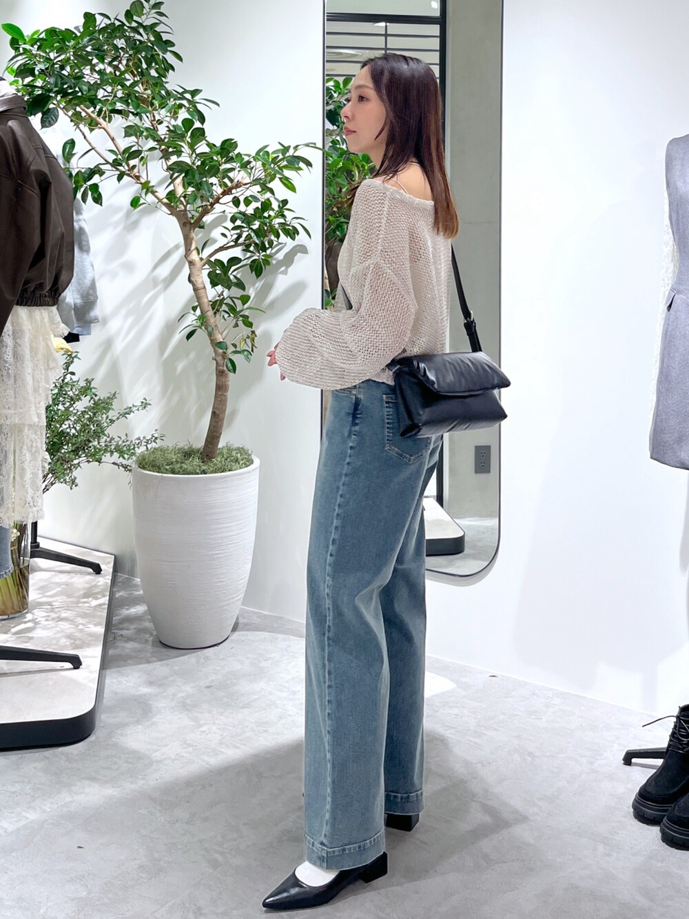 ホワイト系のニット/セーター、ホワイト系のキャミソール、ブラック系のショルダーバッグを着用したレディースの春コーディネートの6枚目の写真