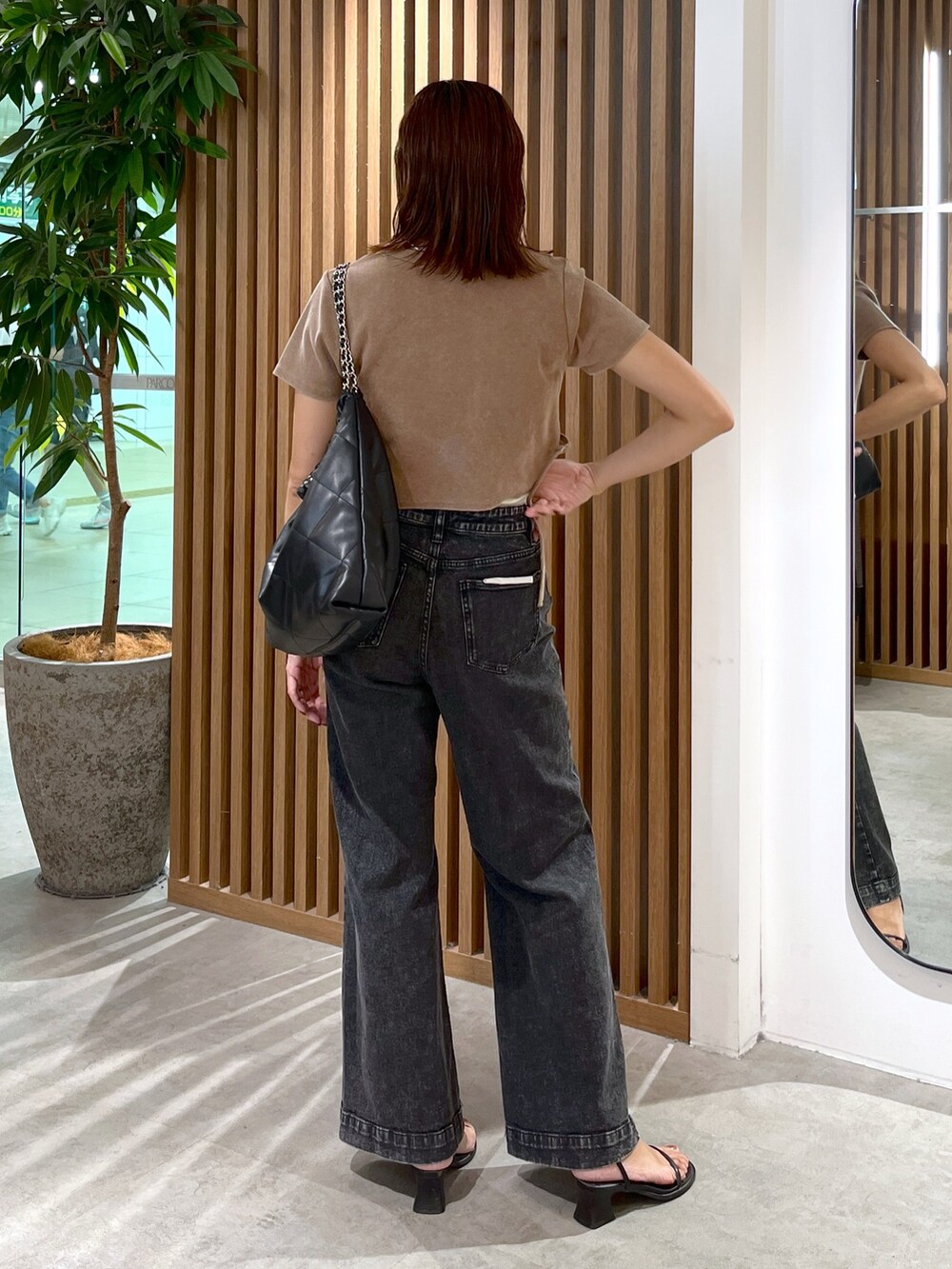 ブラウン系のTシャツ/カットソー、ブラック系のトートバッグ、ブラック系のデニムパンツを着用したレディースの秋コーディネートの7枚目の写真