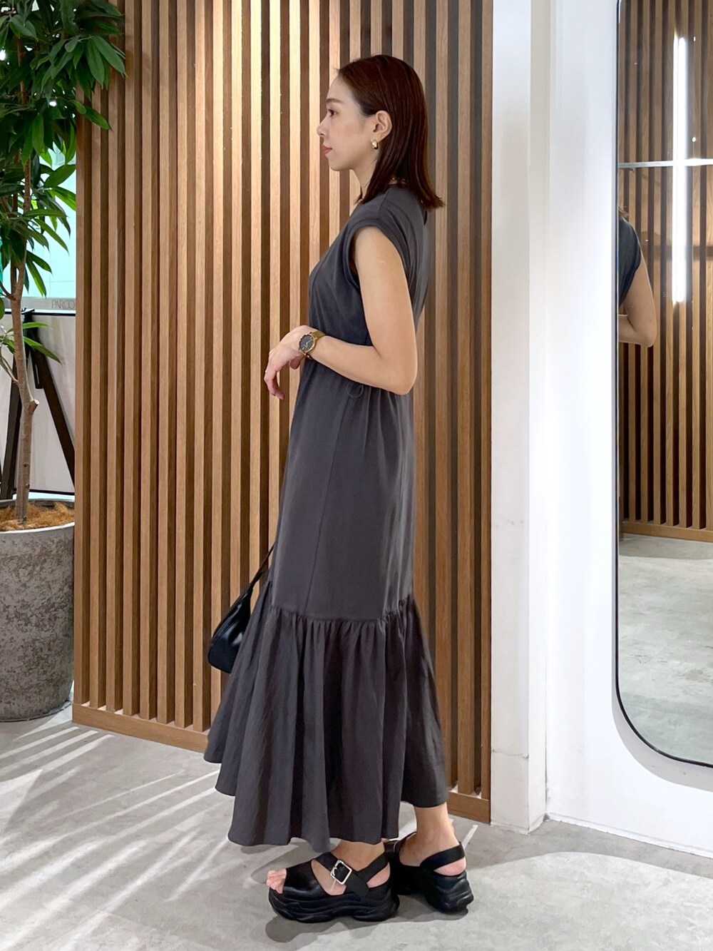 ブラック系のワンピース、ホワイト系のシャツ/ブラウス、ブラック系のサンダルを着用したレディースの夏コーディネートの6枚目の写真