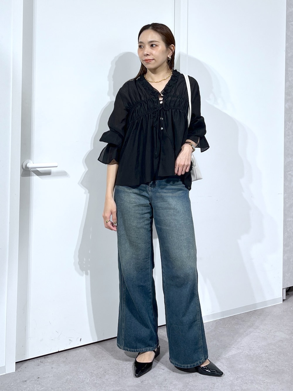 ブラック系のシャツ/ブラウス、ブルー系のデニムパンツを着用したレディースの春コーディネートの3枚目の写真