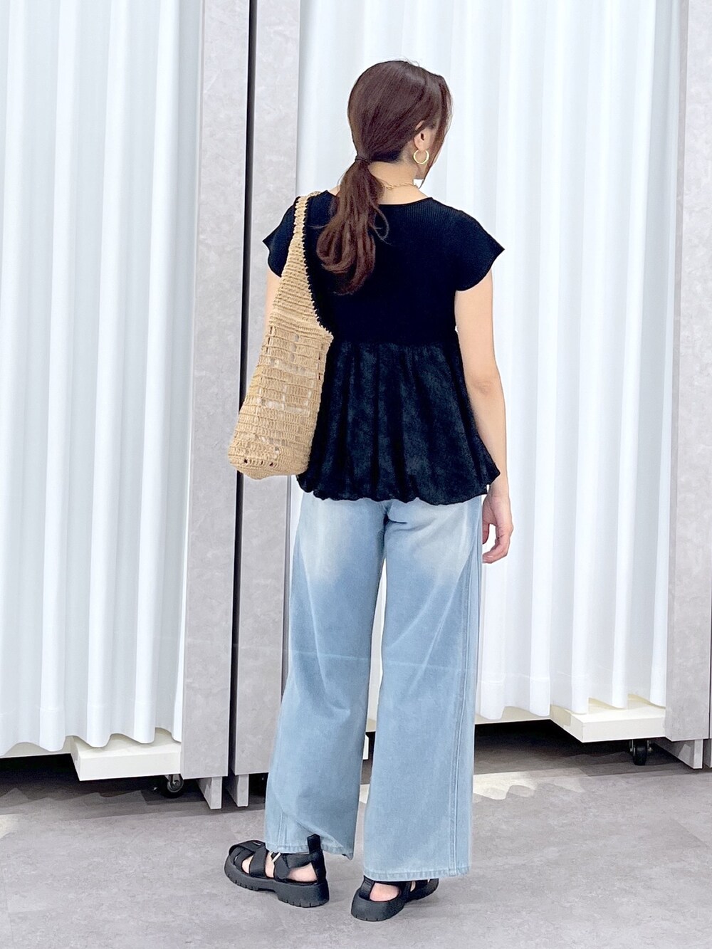 ブルー系のデニムパンツ、ブラック系のニット/セーターを着用したレディースの春コーディネートの4枚目の写真