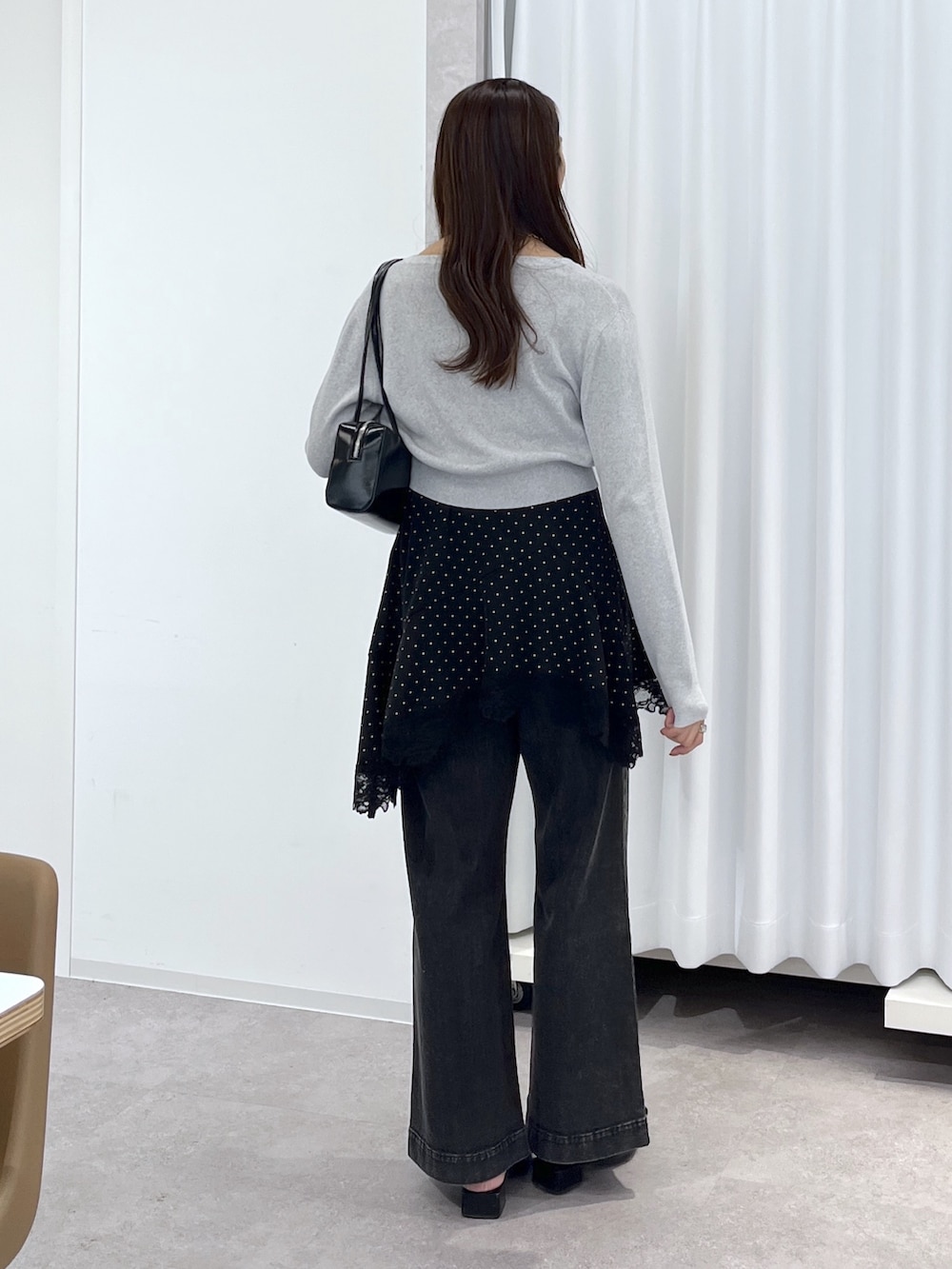 ブラック系のワンピース、ブラック系のデニムパンツ、ブラック系のショルダーバッグを着用したレディースの春コーディネートの4枚目の写真