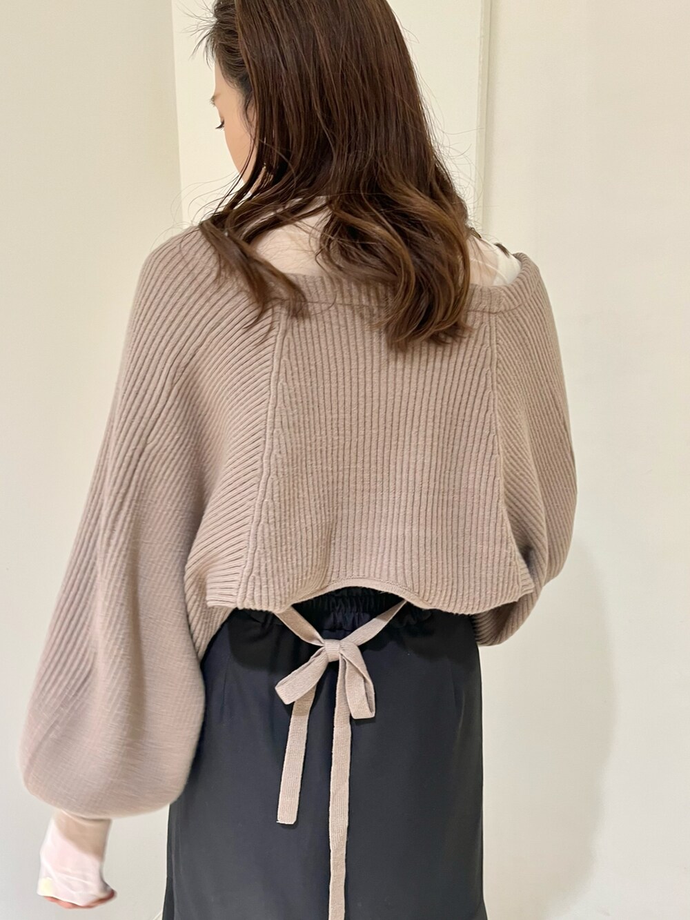 ブラウン系のカーディガン/ボレロ、ブラック系のスカート、ホワイト系のTシャツ/カットソーを着用したレディースの秋コーディネートの4枚目の写真