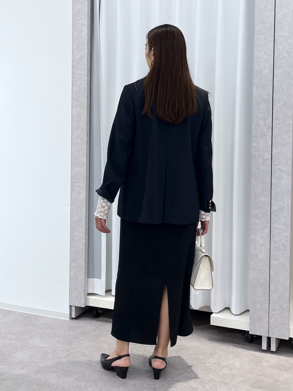 ホワイト系のTシャツ/カットソー、ブルー系のテーラードジャケット、ブラック系のワンピースを着用したレディースの冬コーディネートの5枚目の写真