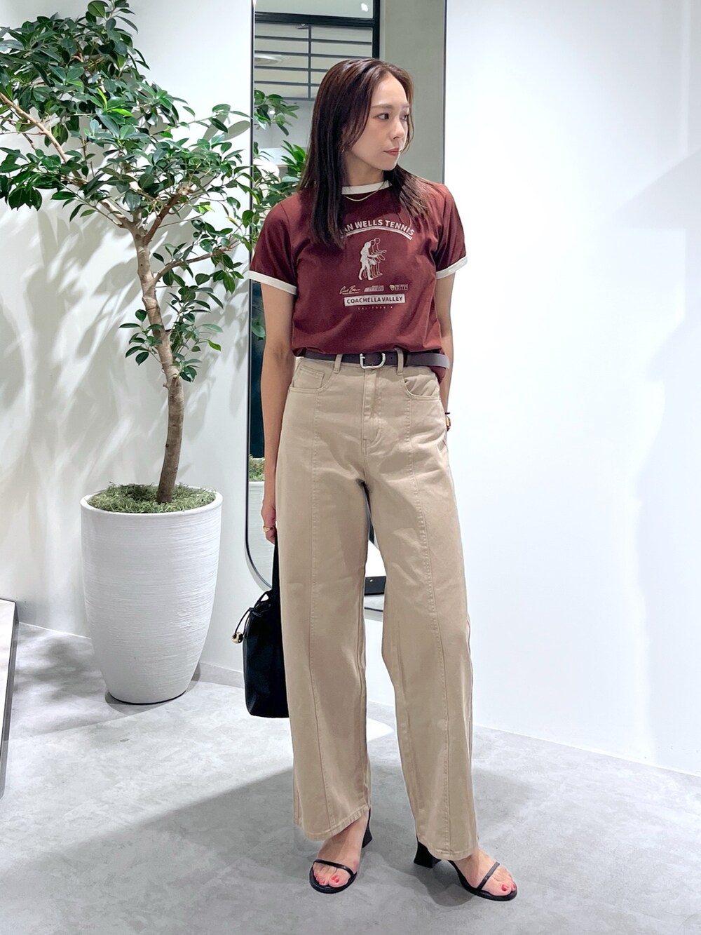 ブラウン系のTシャツ/カットソー、ベージュ系のデニムパンツ、ブラック系のショルダーバッグを着用したレディースの夏コーディネートの3枚目の写真