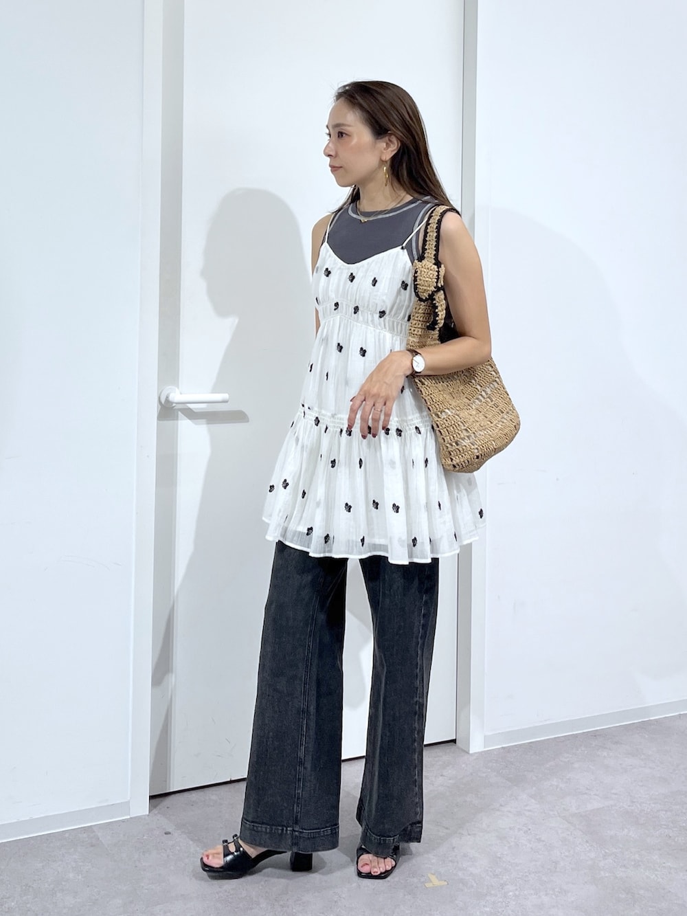 ブラック系のTシャツ/カットソー、ホワイト系のワンピース、ブラック系のデニムパンツを着用したレディースの夏コーディネートの3枚目の写真