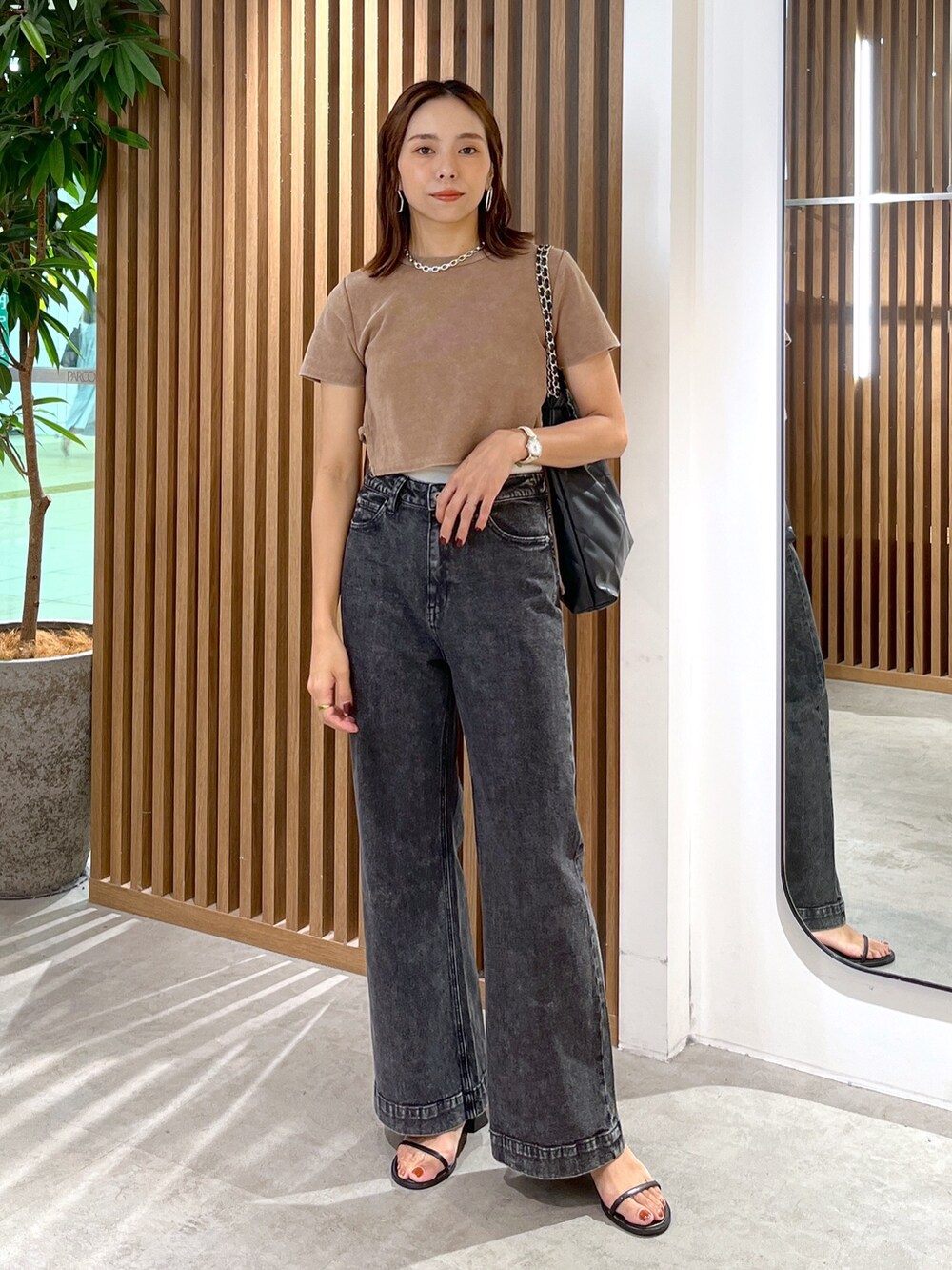 ブラウン系のTシャツ/カットソー、ブラック系のトートバッグ、ブラック系のデニムパンツを着用したレディースの秋コーディネートの8枚目の写真