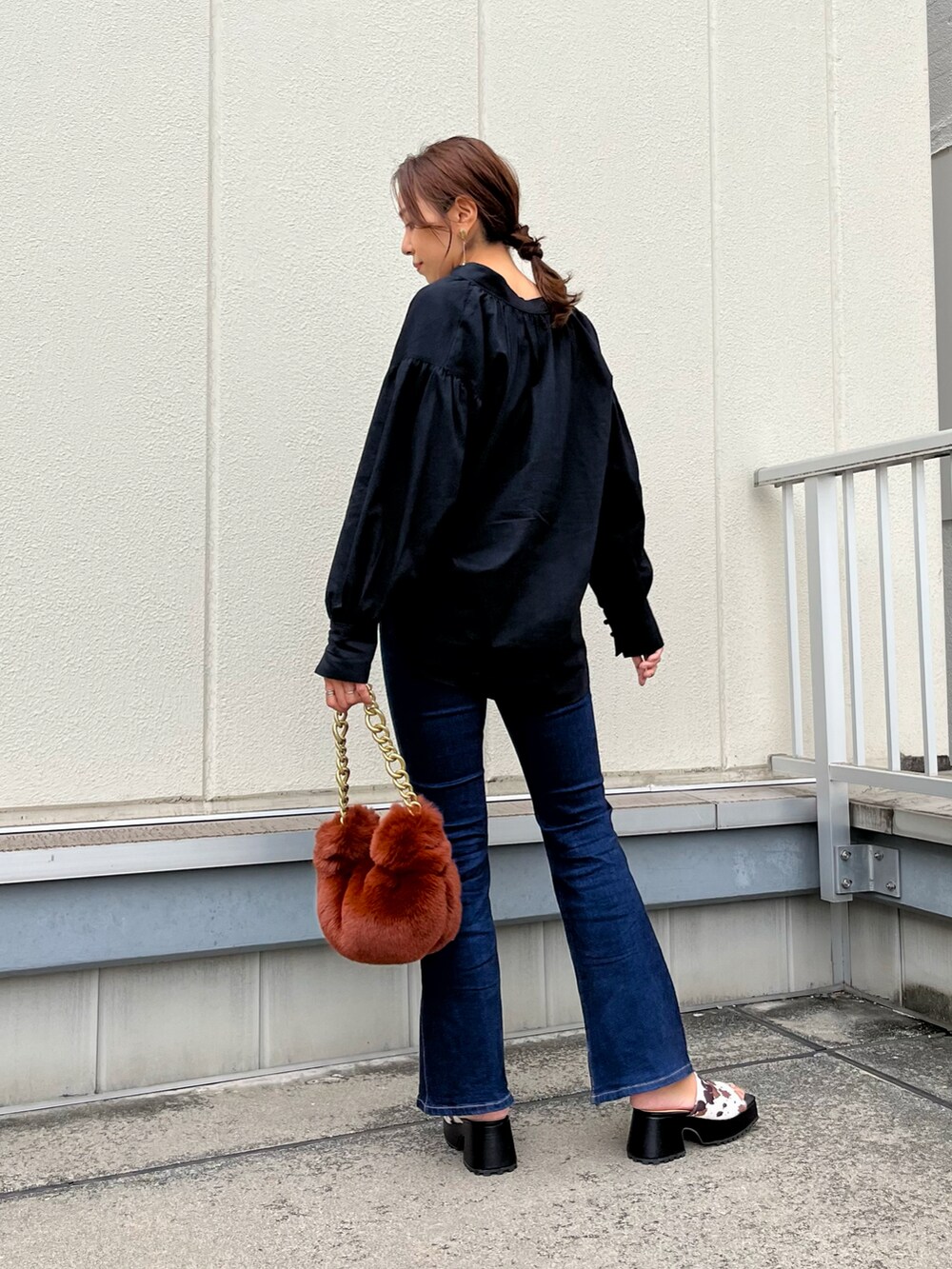 ブラック系のシャツ/ブラウス、ブラウン系のハンドバッグ、ホワイト系のサンダルを着用したレディースの秋コーディネートの3枚目の写真