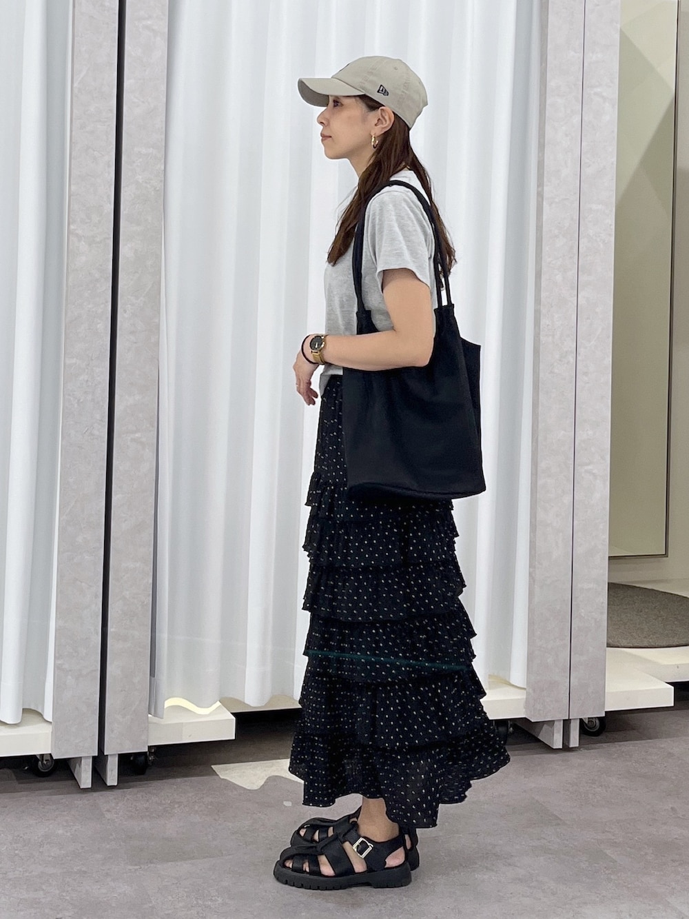ブラック系のトートバッグ、ブラック系のスカート、グレー系のTシャツ/カットソーを着用したレディースの春コーディネートの3枚目の写真