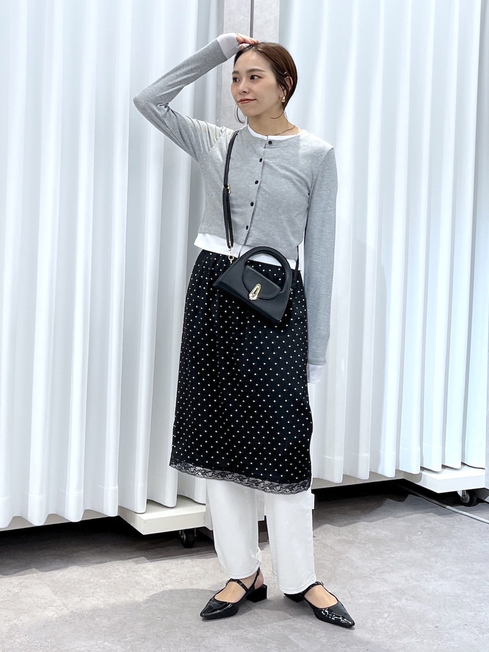 ブラック系のスカート、グレー系のTシャツ/カットソー、ホワイト系のデニムパンツを着用したレディースの春コーディネートの3枚目の写真