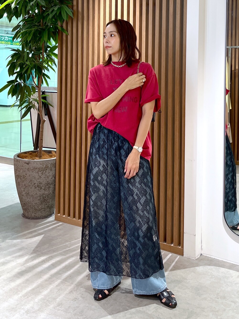 レッド系のTシャツ/カットソー、ブラック系のハンドバッグ、ブルー系のデニムパンツを着用したレディースの夏コーディネートの8枚目の写真