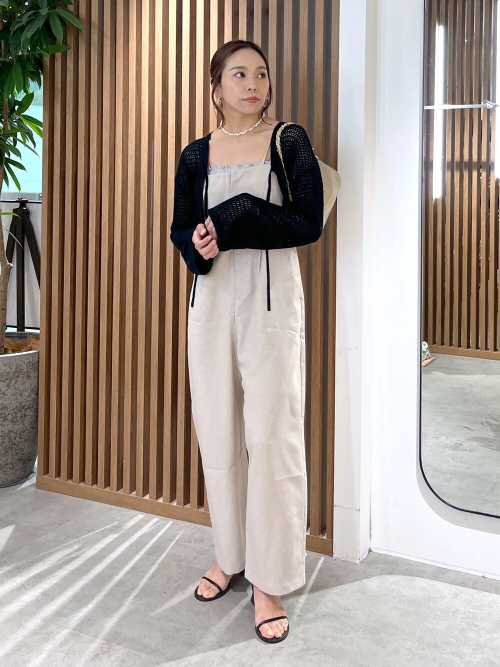 ブラック系のカーディガン/ボレロ、グレー系のキャミソール、ベージュ系のトートバッグを着用したレディースの夏コーディネートの2枚目の写真