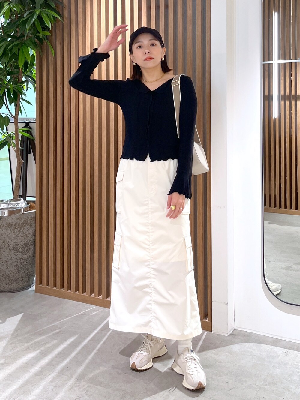 ホワイト系のボディバッグ/ウエストポーチ、ブラック系のトップス、ホワイト系のスカートを着用したレディースの春コーディネートの3枚目の写真