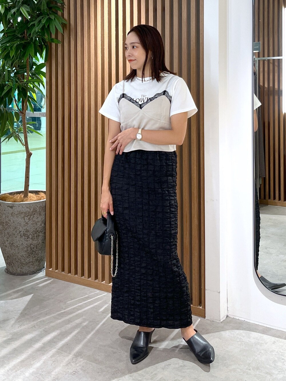 ブラック系のスカート、ホワイト系のTシャツ/カットソー、グレー系のキャミソールを着用したレディースの秋コーディネートの6枚目の写真