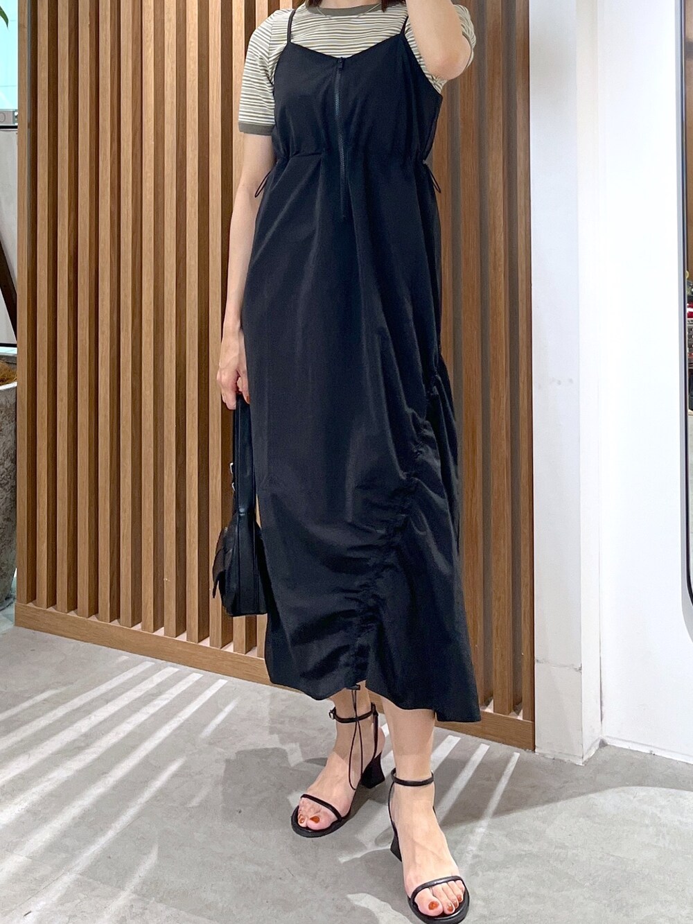 グリーン系のTシャツ/カットソー、ブラック系のショルダーバッグ、ブラック系のサンダルを着用したレディースの春コーディネートの5枚目の写真