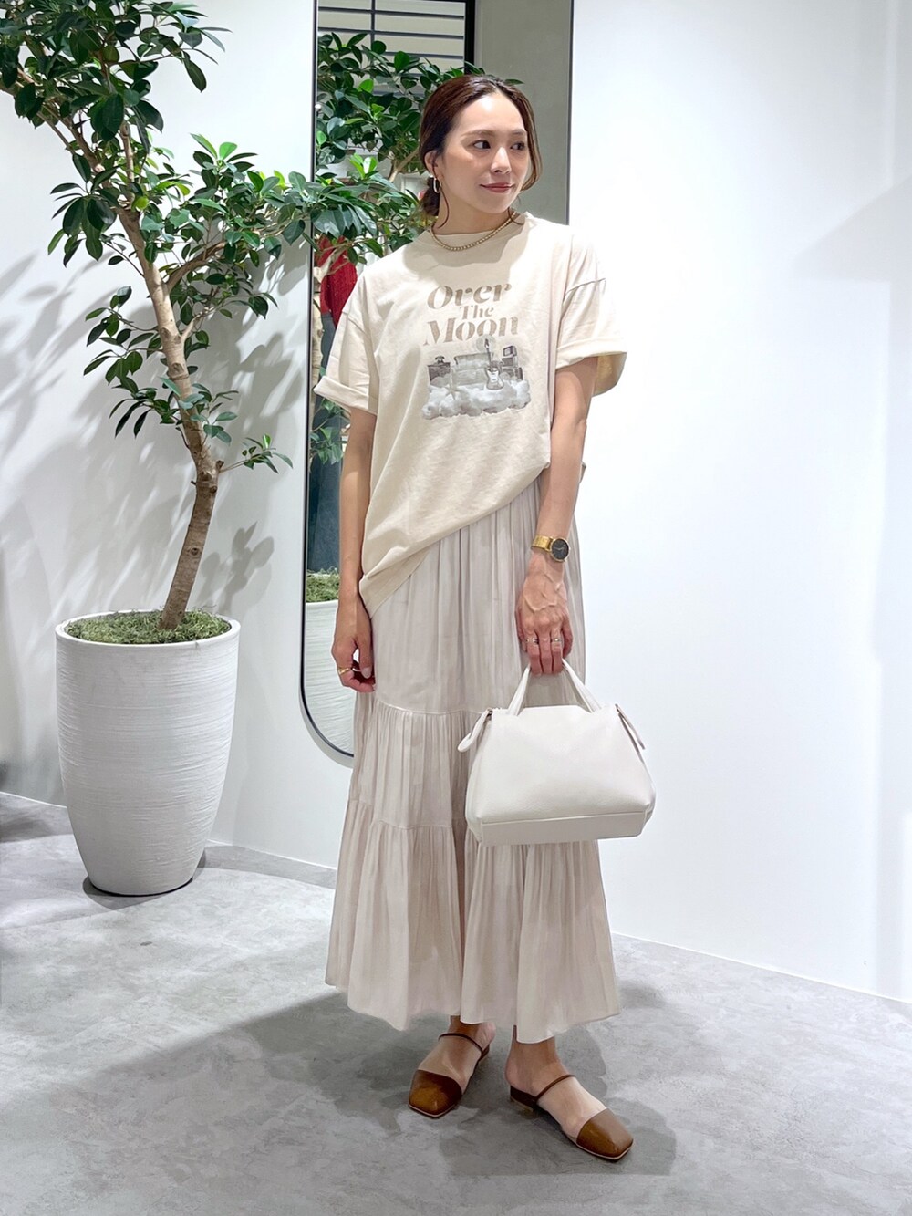 ベージュ系のTシャツ/カットソー、ホワイト系のショルダーバッグ、ホワイト系のスカートを着用したレディースの春コーディネートの2枚目の写真