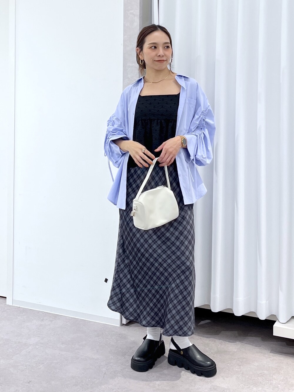 ホワイト系のハンドバッグ、ブルー系のシャツ/ブラウス、ブラック系のシャツ/ブラウスを着用したレディースの春コーディネートの3枚目の写真