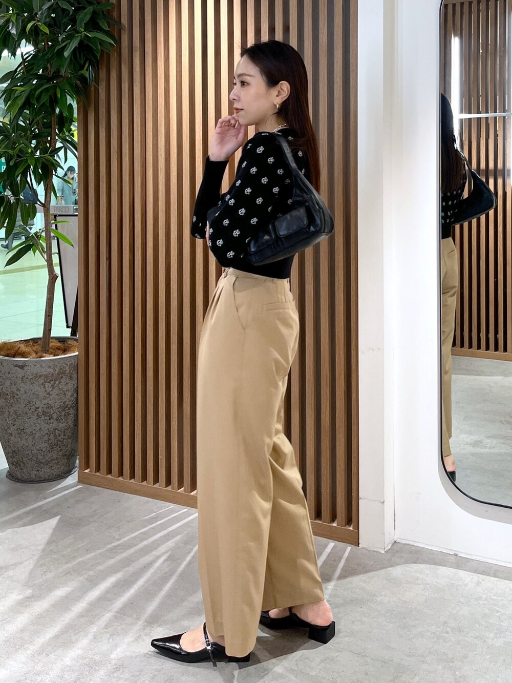 ブラック系のパンプス、ブラック系のショルダーバッグ、ブラック系のニット/セーターを着用したレディースの冬コーディネートの6枚目の写真