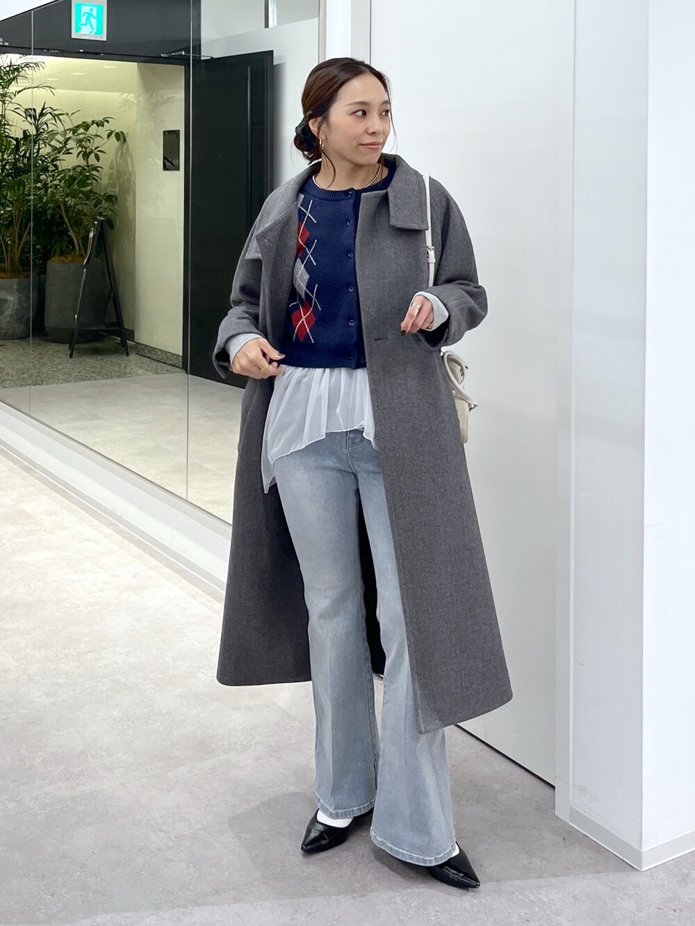 ホワイト系のTシャツ/カットソー、グレー系のステンカラーコート、ブルー系のニット/セーターを着用したレディースの秋コーディネートの5枚目の写真