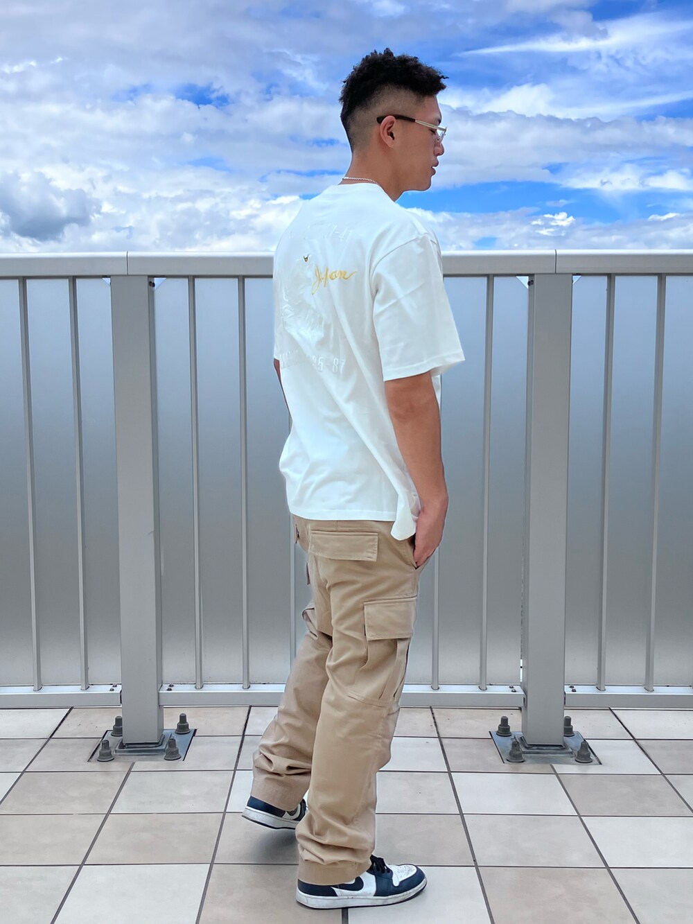 ホワイト系のTシャツ/カットソー、グリーン系のカーゴパンツ、グレー系のサングラスを着用したメンズの夏コーディネートの2枚目の写真