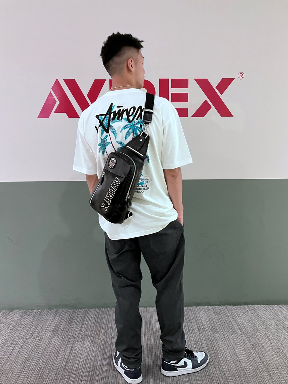 ブラック系のショルダーバッグ、グレー系のその他パンツ、ホワイト系のTシャツ/カットソーを着用したメンズの夏コーディネートの2枚目の写真